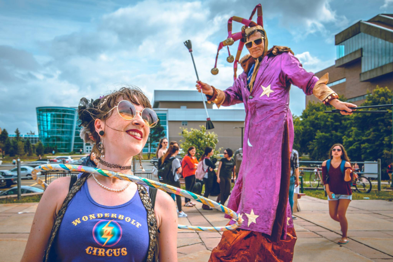 Susan hula hooping beside a performer on stilts