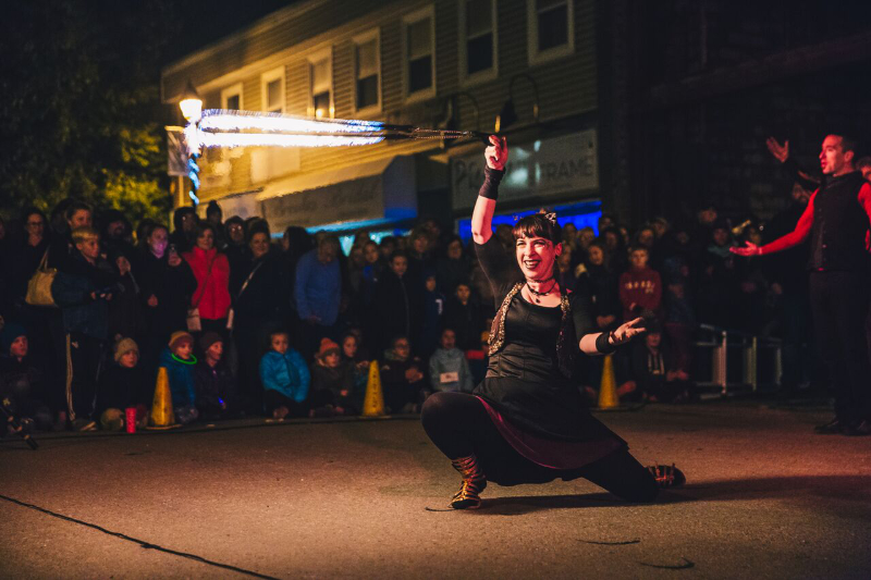 Susan spinning a flaming skipping rope in front of a large audience