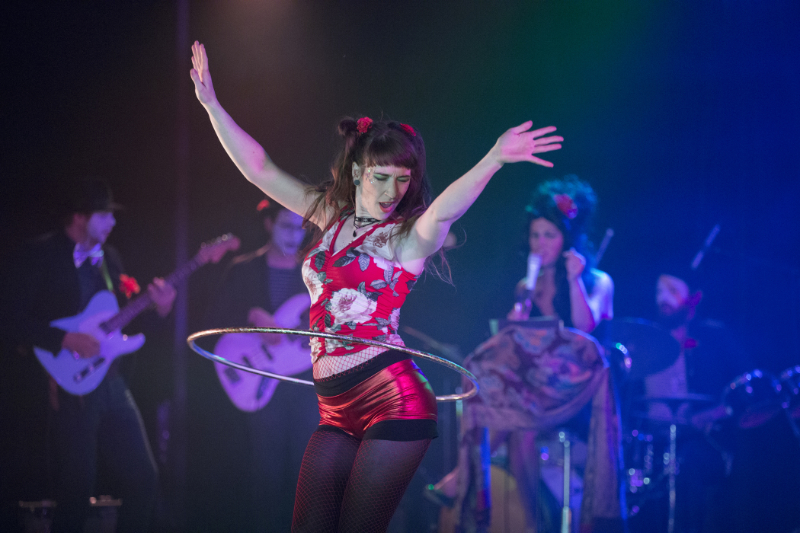 Susan hula hooping on stage, in front of a live band